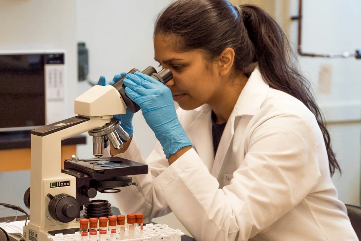 Researcher looking through a microscope
